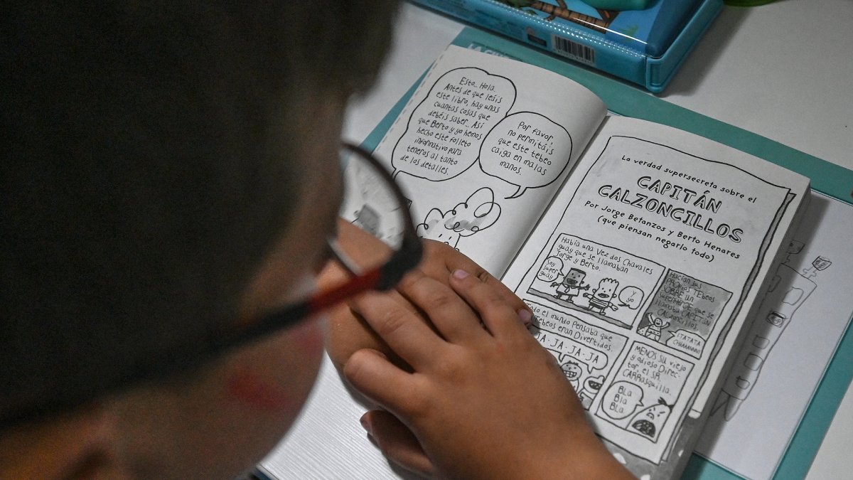 Un joven lector disfruta de la lectura de su libro.