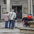 Una pareja de jubilados y una mujer de mediana edad frente al Ayuntamiento de Burgos.