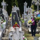 Una mujer camina entre las lápidas del cementerio. ECB