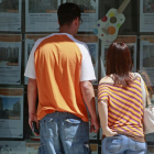 Una pareja observa anuncios de pisos de una inmobiliaria.-RAÚL G. OCHOA