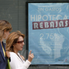 Dos mujeres pasan frente al anuncio sobre hipotecas de una entidad bancaria.-RAÚL G. OCHOA