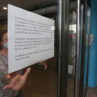 Una empleada del centro cívico de Río Vena coloca el aviso de que se suspenden las actividades por decreto del alcalde. RAÚL OCHOA