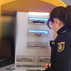 Una agente de la Policía Nacional inspecciona un cajero automático. ECB