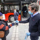Un empleado de Autobuses entrega una mascarilla a una viajera. SANTI OTERO