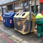 Un operario municipal repinta uno de los contenedores incendiados anoche en la calle Vitoria. RAÚL OCHOA