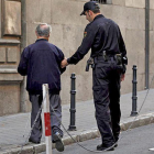 Un agente ayuda a una persona mayor.-ECB