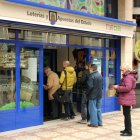 Varios burgaleses esperan su turno para comprar lotería en la administración ‘Don Pepe’ de Gamonal.-JAIME CARAZO