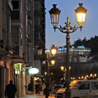 En la calle del Carmen, ayer mismo, se ve como solo alumbra uno de los dos puntos de luz de cada farola.-ISRAEL L. MURILLO