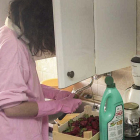 Una mujer limpia fruta en una cocina. ECB