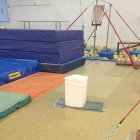 Un cubo en mitad del gimnasio para recoger las goteras.-ECB