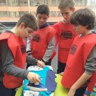 Cuatro niños ataviados con petos rojos forman un equipo y realizan la tarea de plancha.-ECB
