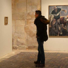 Un visitante observa una de las pinturas y da la espalda a esta imagen de ciclistas que hacía más de setenta años que no se mostraba.-Ricardo Ordóñez (ICAL)