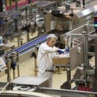 Un operario pone en funcionamiento una de las máquinas de una fábrica de la Comunidad.-E.M.