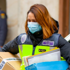 Una agente de la Policía sale del domicilio de Pompeyo G.P., en Miranda de Ebro, con varias cajas que contienen material incautado. ICAL