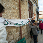 Los vecinos colocan una pancarta en el edificio del centro municipal donde se desarrollaron las elecciones el pasado 28 de mayo.