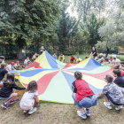 Los niños del campamento urbano de Fuentes Blancas se conocen gracias al juego del paracaídas.