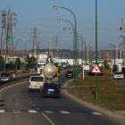 Varios vehículos transitan por la calle López Bravo, en el polígono industrial de Villalonquéjar.