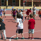 Varios niños y niñas juegan en el patio de un colegio.