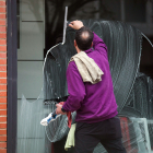 Un hombre limpia el escaparate de un establecimiento comercial en Burgos.