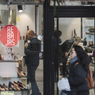 Varias personas miran calzado en una tienda local de la capital burgalesa.