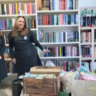 Arantzazu Suances y Sylvia Cernadas, las libreras de La Silla Mágica, con el material donado que llenaba el escaparate y parte de su librería.