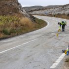 Dos agentes de la Guardia Civil de Tráfico hacen mediciones en el lugar del accidente de la Carretera Poza.