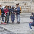 Un grupo de turistas de origen asiático se fotografían a su paso por la Catedral de Burgos.