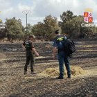 Un Guardia Civil y un agente medio ambiental inspeccionan la zona.
