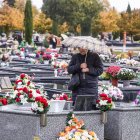 Una mujer visita la sepultura de un ser querido.