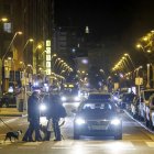 Peatones cruzando por la avenida Reyes Católicos, de Burgos, con el alumbrado público encendido.
