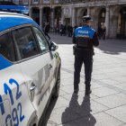 Un agente de Policía Local junto al vehículo oficial, en la Plaza Mayor de Burgos.
