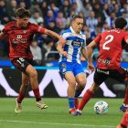 Los rojillos Bauza y Novoa intentan robar el balón al deportivista Luismi Cruz