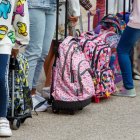 Un grupo de niños y niñas esperan para entrar al colegio.