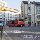 Un agente de servicio en la plaza del Cid, mientras al fondo pasa un autobús municipal.