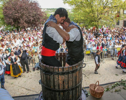 Dos jóvenes pisan la uva durante la Fiesta de la Vendimia de la Denominación de Origen Arlanza.-ECB