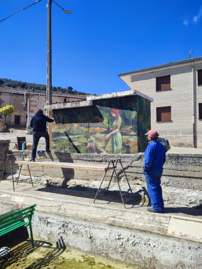 Mateos pinta el mural ante la presencia de un vecino de la localidad.