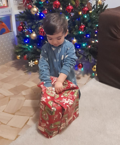Gioele, un pequeño italiano con raíces burgalesas, abriendo su regalo de Reyes.