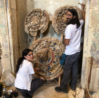 Lara y Alejandro, restauradores, recuperan las claves de madera del cenobio.