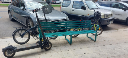 Bicis y patinete amarrados a un banco en la avenida de la Paz de Burgos.