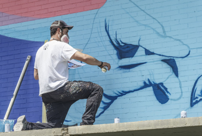 Christian trabajando en el mural del centro de salud José Luis Santamaría.