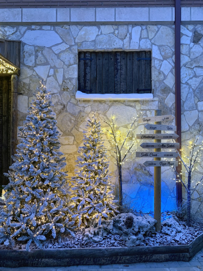 Exterior del Belén de Renuncio, decorado con Árboles de Navidad nevados, como si fuera un pueblo de Laponia.