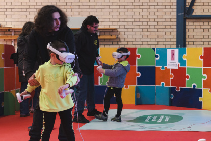 Dos monitores ayudan a dos niños con un sistema de realidad virtual.