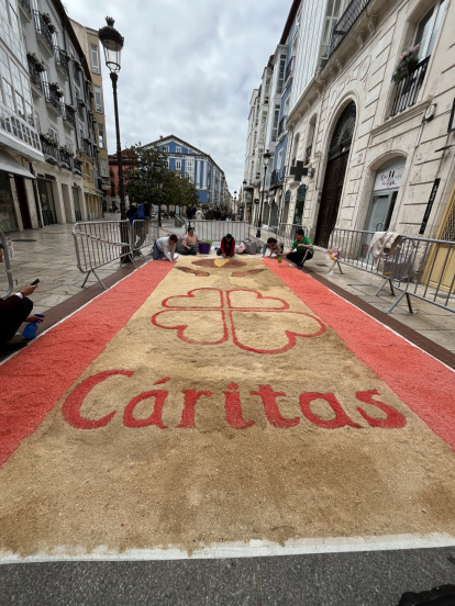 La imagen de Cáritas realizada en serrín decora la calle Láin Calvo