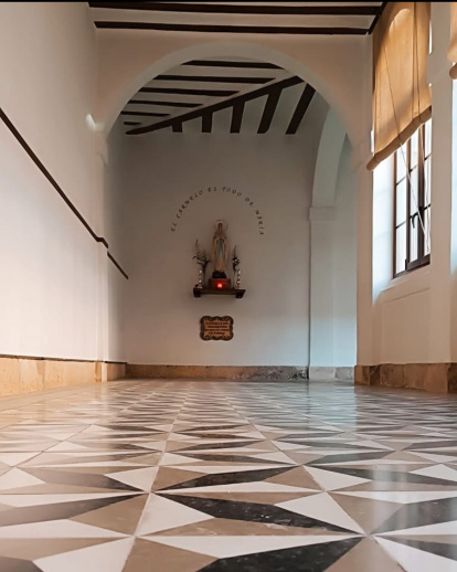 El enlosado del claustro refleja la luz de las ventanas.