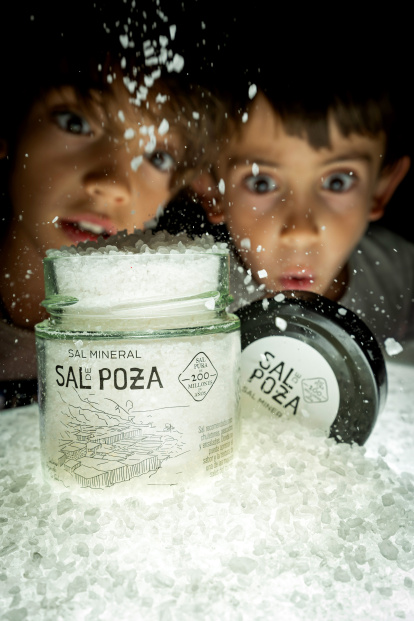 Dos niños contemplan la sal extraída en Poza