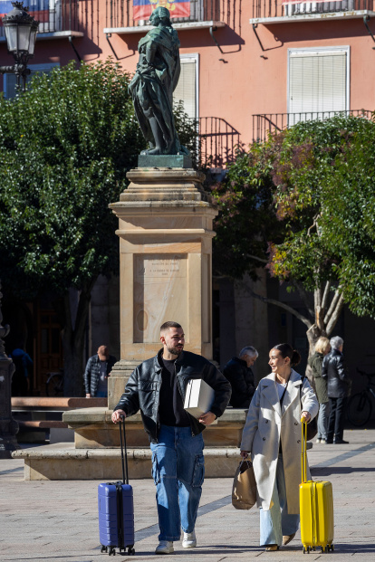 Personas con maletas pasean por las calles de Burgos, en un fin de semana reciente.